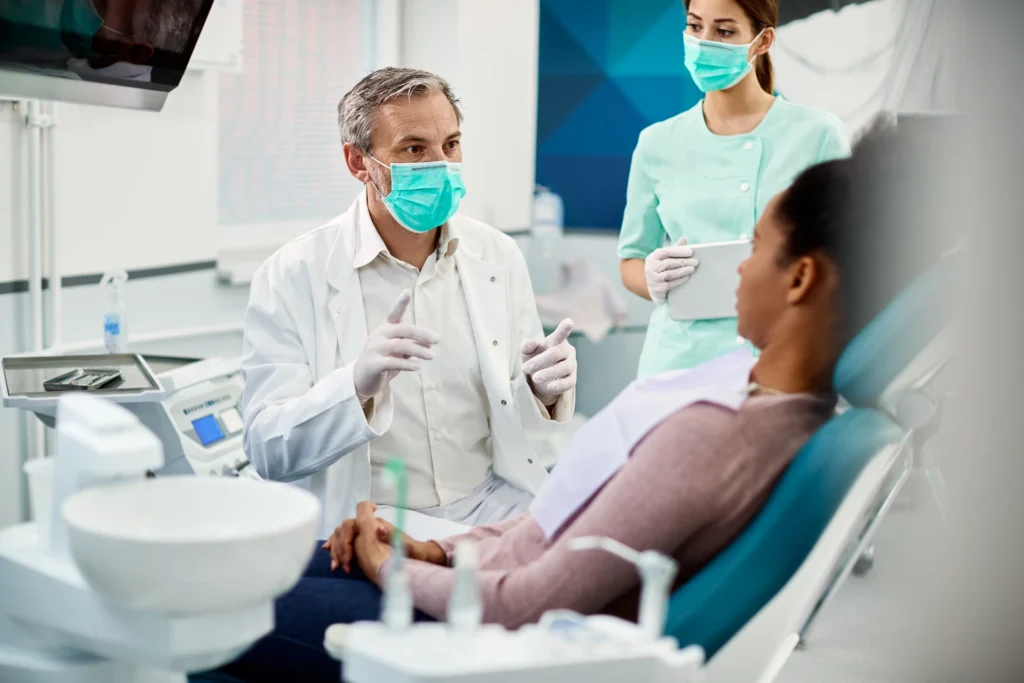 Mature dentist with face mask talking to black fem 2023 02 02 18 49 58 utc